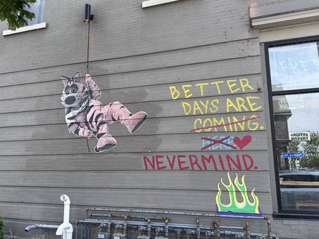 A mural reading Better days are coming, crossed out, then Nevermind