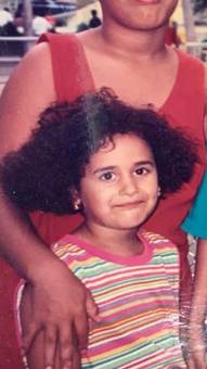 A small girl with curly hair in a striped shirt