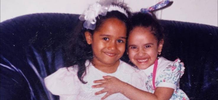 Jessenia as a child, hugging another little girl