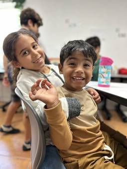 Two children smiling in a classroom