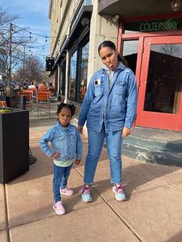 Jessenia and a little girl in matching denim, both sticking out their tongues