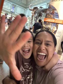 Jessenia and a child laughing in a natural history museum