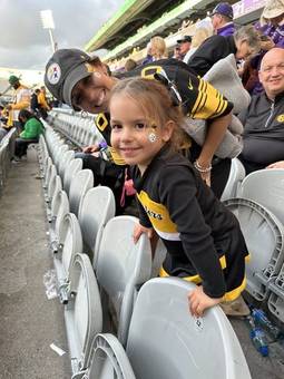 A little girl in team colours at a stadium
